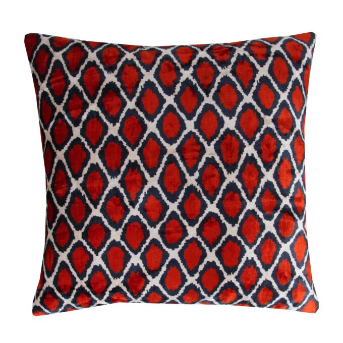 "Close-up view of a luxurious silk cushion cover in deep velvet red, showcasing an intricate Ikat pattern in shimmering gold threads. The soft, tactile texture of the silk velvet is highlighted, inviting touch and admiration. This elegant decorative accent adds sophistication and opulence to any room, whether placed on a sofa, chair, or bed. Handcrafted with care and attention to detail, it embodies the rich textile traditions of Uzbekistan, making it a timeless statement piece for discerning decor enthusiasts."